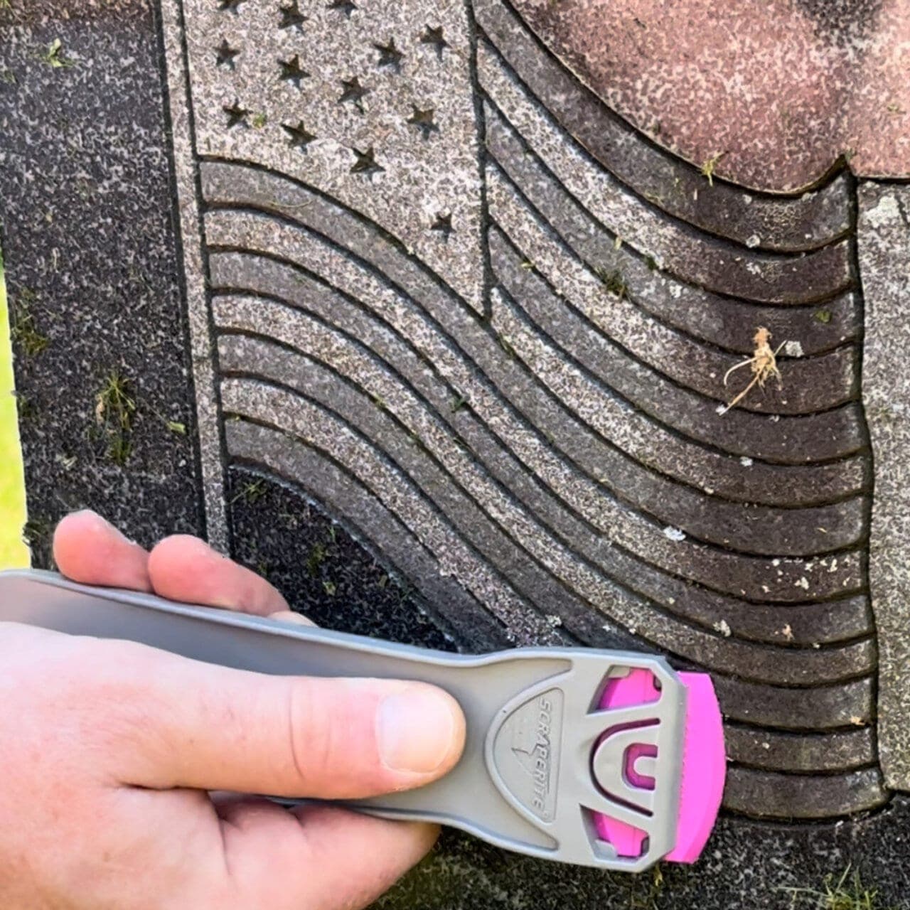 Person using Scraperite Pro Magenta Blade to clean monument surface