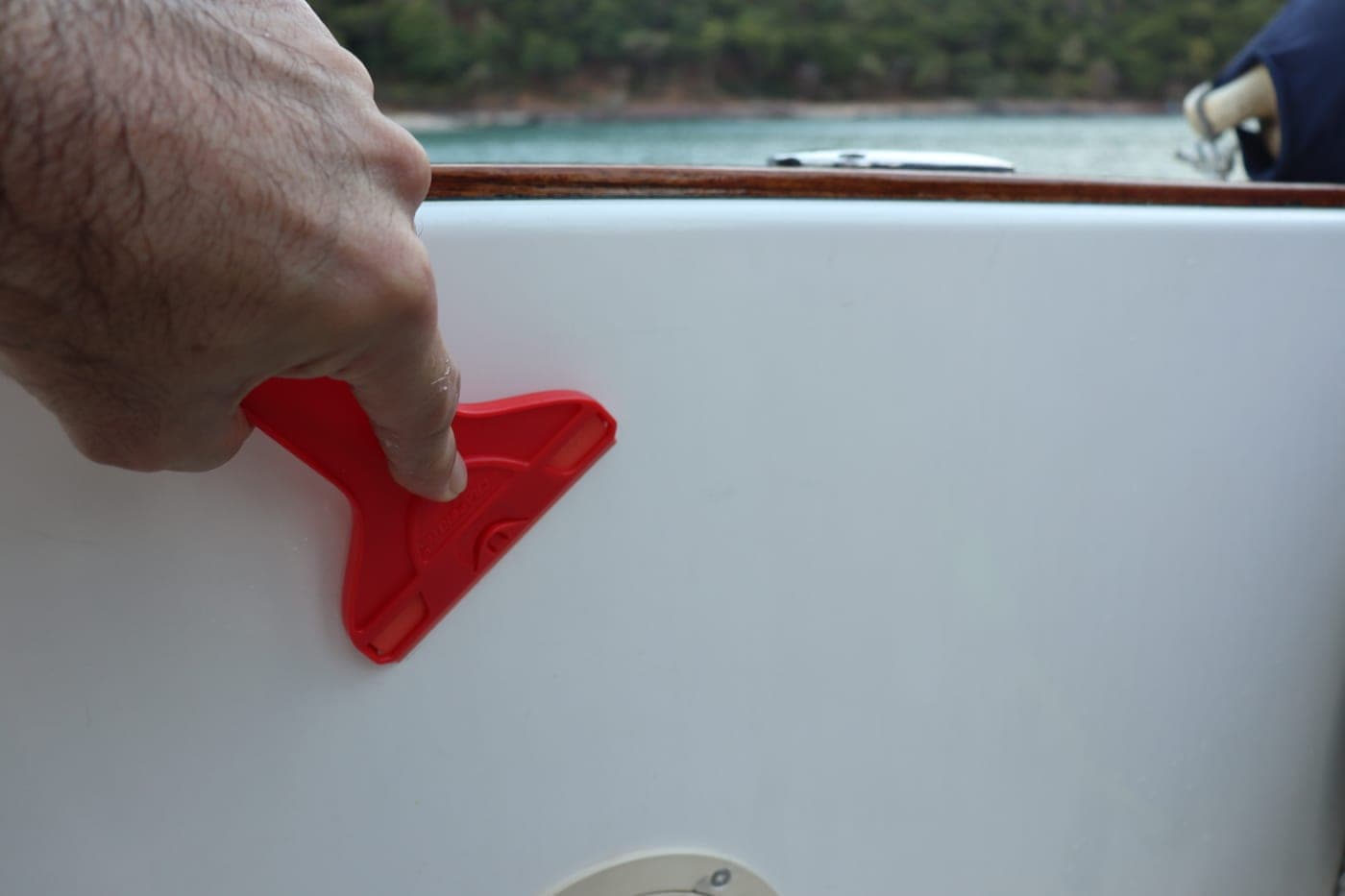 Scraperite Hand Using Red Scraperite Tool On Boat Surface